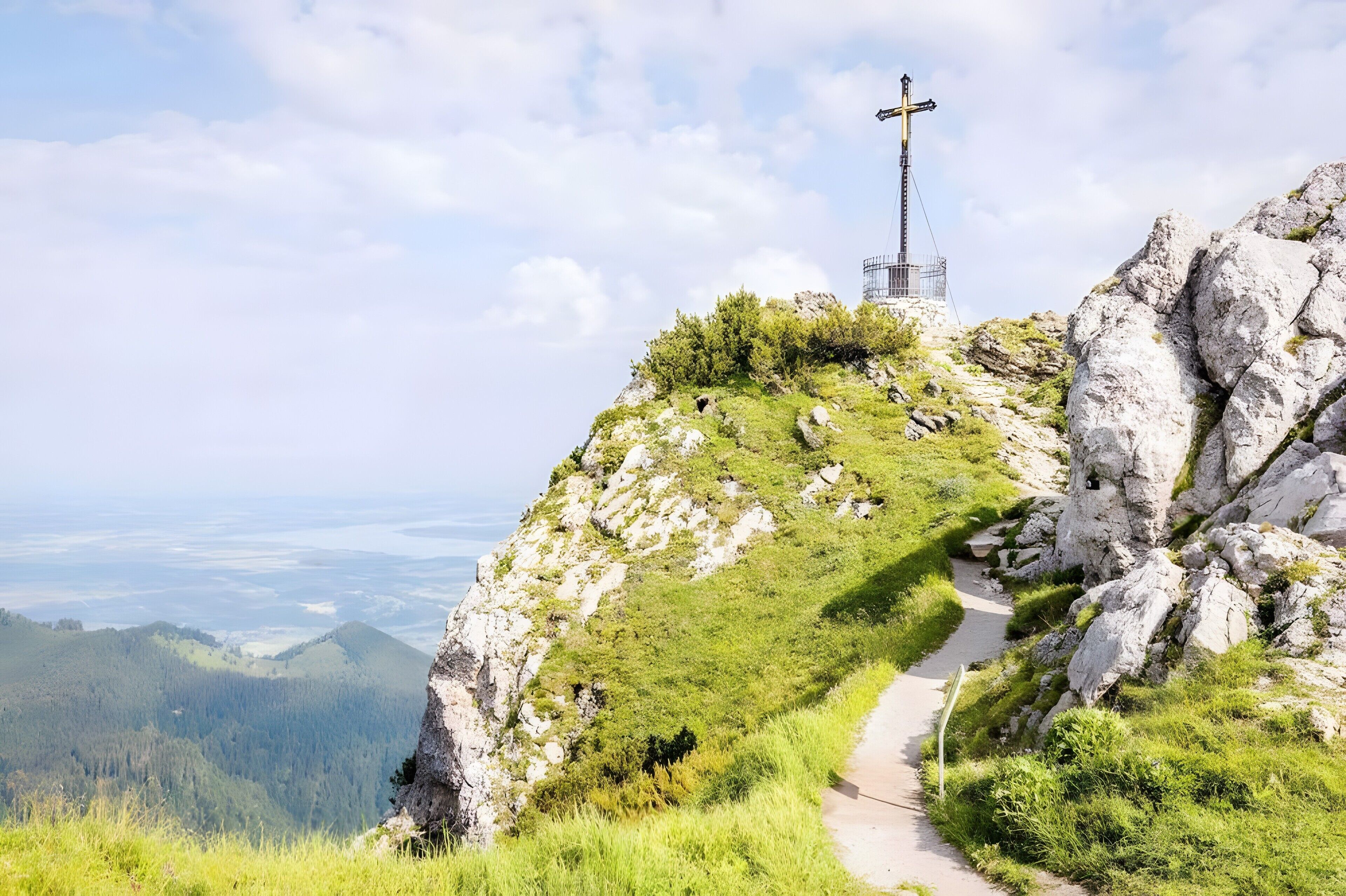 Ein Kreuz auf einem Hügel, mit einem Weg, der dorthin hinaufführt.