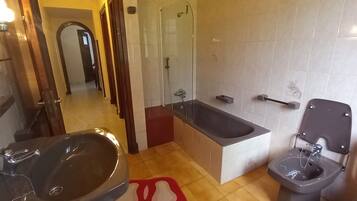 Een douche, een bidet, zeep, toiletpapier