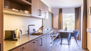 A modern kitchen with a central island, built-in appliances, and a dining area with a view of the outdoors.