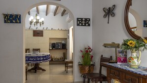 A dining area with a table set for two, a chandelier, and a decorative vase with flowers. - House in Pollensa near Cala Barqués Beach (Pollensa)