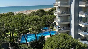 Un hôtel à plusieurs étages doté d’une piscine et offrant une vue sur la plage.