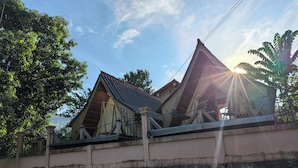 A building with a sloped roof and a stone wall foundation. - Mango Villa Nong Khiaw (Nong Khiaw)