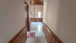 A hallway with wooden paneling and white tiled flooring. - Mango Villa Nong Khiaw (Nong Khiaw)