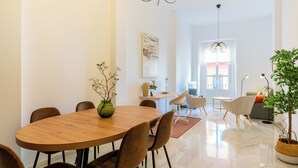 Un comedor moderno con una mesa de madera, sillas marrones y un jarrón con flores.