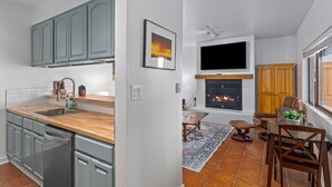Una cucina moderna con mobili grigi, un piano di lavoro in legno e una lavastoviglie integrata.