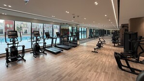Moderni kuntosali, jossa on juoksumattoja, kuntopyöriä ja painonnostolaitteita.