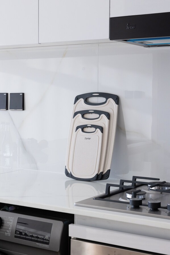 A kitchen with a white countertop, a gas stove, and a dishwasher.