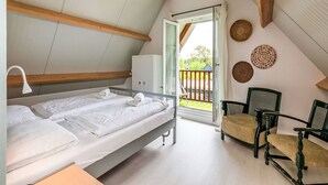 Une chambre à coucher comprenant un lit, une chaise, un bureau et une armoire.