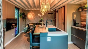 Una cucina moderna con un'isola centrale, una zona pranzo con sedie blu e un lampadario.