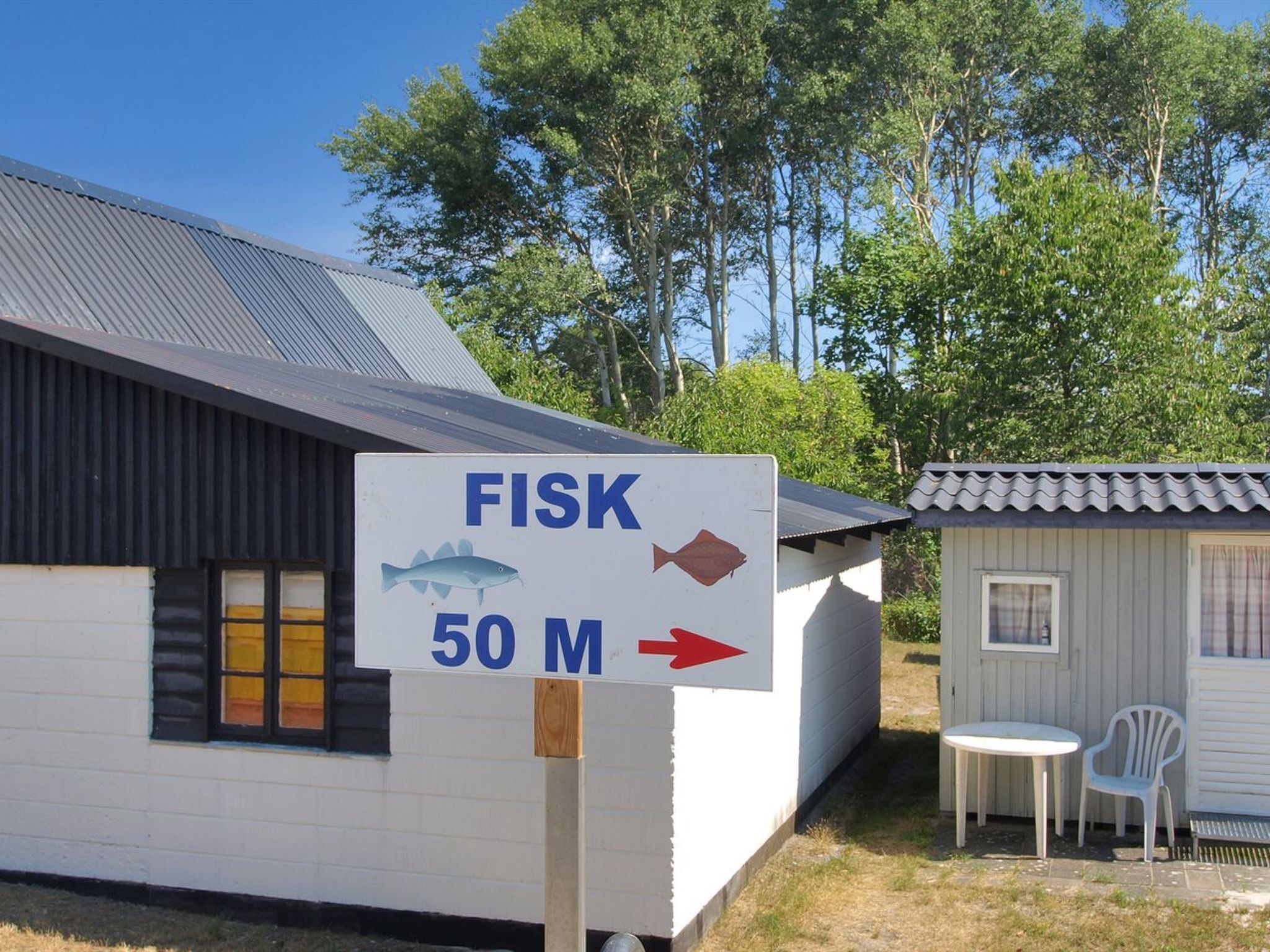A building with a sign indicating a fish market 50 meters to the right.