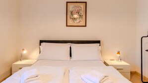 A hotel room with a bed, two nightstands, and a framed picture on the wall. - Lovely apartment for 3 guests with A/C, WIFI, TV, patio, pets allowed and panoramic view (Malcesine)