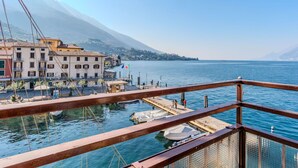 A waterfront view with buildings, a dock, and boats. - Lovely apartment for 3 guests with A/C, WIFI, TV, patio, pets allowed and panoramic view (Malcesine)