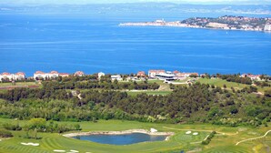 Un parcours de golf avec un lac, entouré d’arbres et de bâtiments.