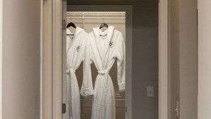 Un couloir dans lequel sont suspendues deux robes blanches sur un portant.