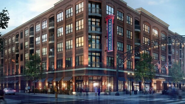 Un hôtel à plusieurs étages, reconnaissable à son grand panneau « Urban Chop House », avec une façade en briques et de nombreux balcons.