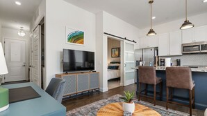 Un salon moderne avec un téléviseur, des sièges et une table basse.