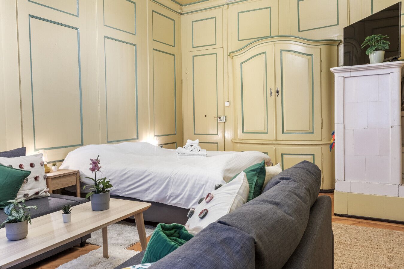 Ein Schlafzimmer mit Bett, Sofa, kleinem Tisch und Schrank.