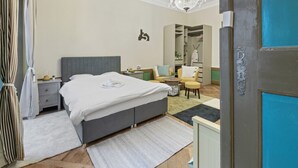 Et soveværelse med seng, sengeborde, en stol, et lille bord, et spejl og et garderobeskab.