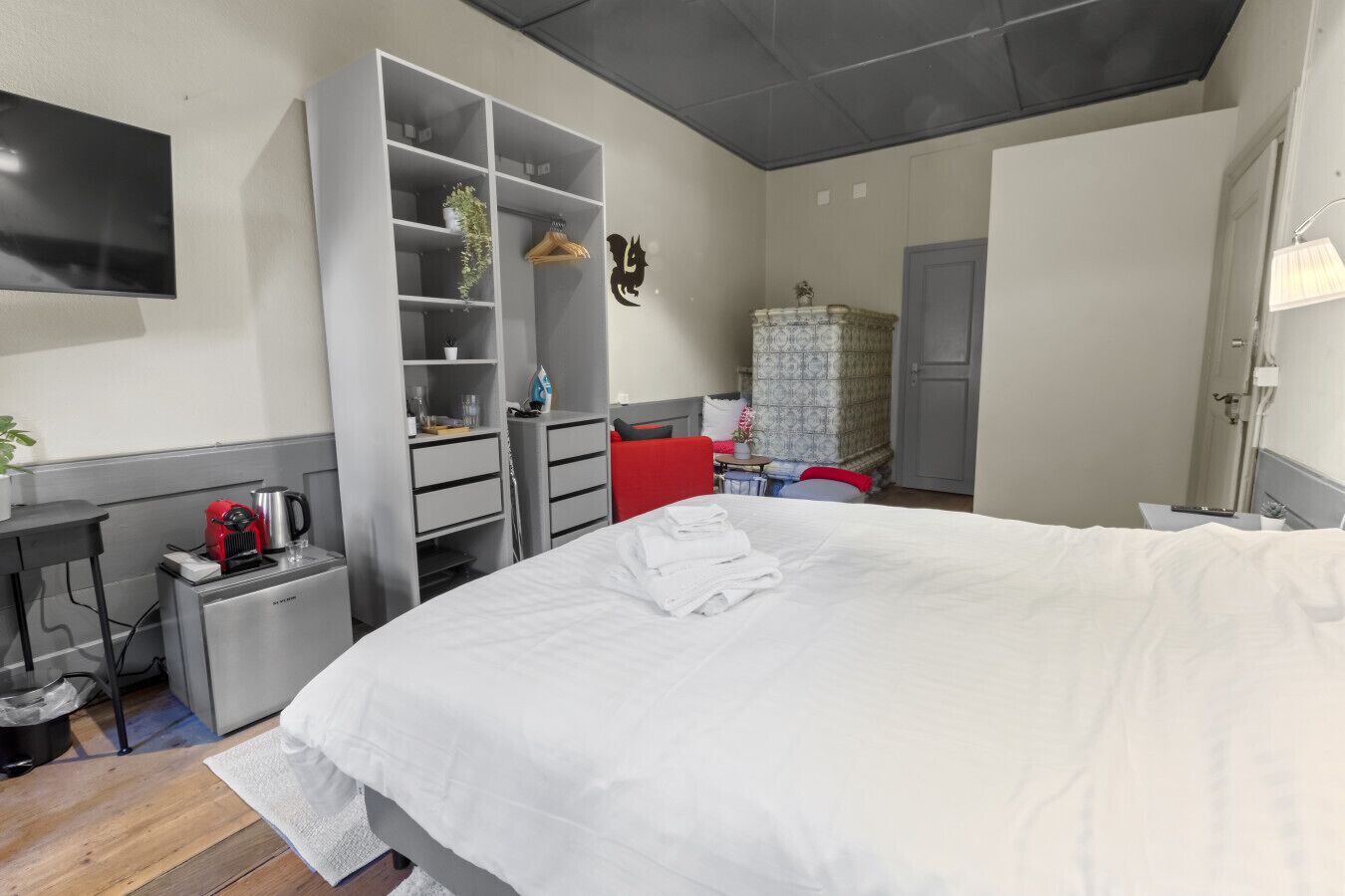 Ein Schlafzimmer mit Bett, Kleiderschrank, Schreibtisch und Fernseher.