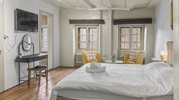 A bedroom with a bed, a desk, a chair, and a TV. - Charming studio in Fribourg's old town (Fribourg)