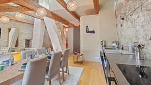 Un espace de restauration moderne, avec des poutres en bois apparentes, un mur en pierre rustique et un design minimaliste.
