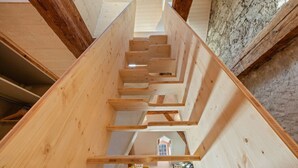 Un escalier en bois offrant une vue sur une maison à travers les interstices.