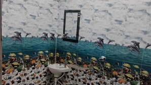 A bathroom with a dolphin mural, a sink, and a shower. - TabTrips Bhakti Dham Stay (Varanasi)