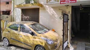 A yellow car parked in front of a building with a sign that reads "Bhakti Dham Home Stay." - TabTrips Bhakti Dham Stay (Varanasi)