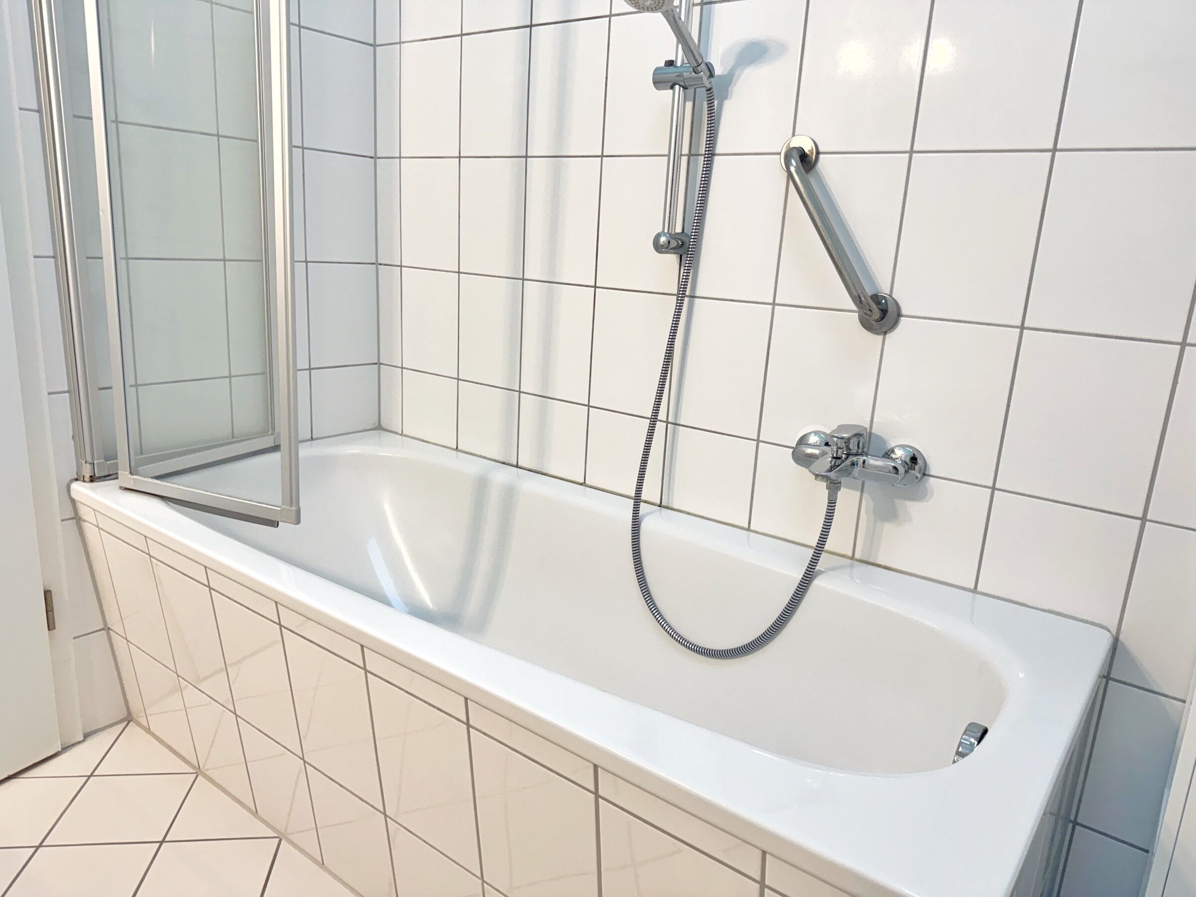 Ein modernes Badezimmer mit Badewanne, Dusche und einer gläsernen Duschkabine.