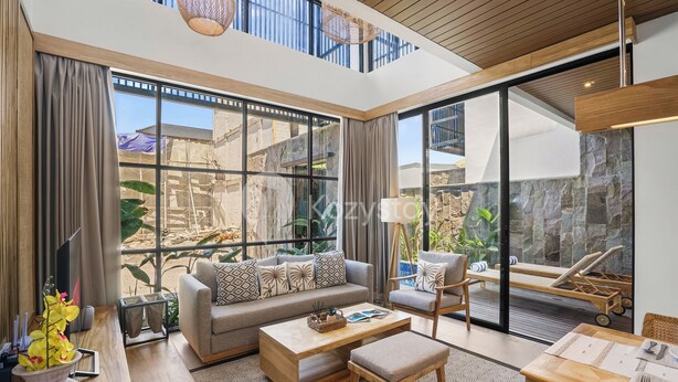 A spacious living room with a large window, a sofa, a coffee table, and a dining area.