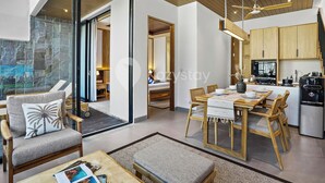A modern interior with a dining area, kitchen, and a large sliding glass door leading to a balcony.