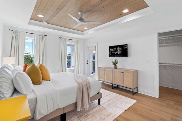A bedroom with a bed, a ceiling fan, a wooden cabinet, and a sign on the wall.