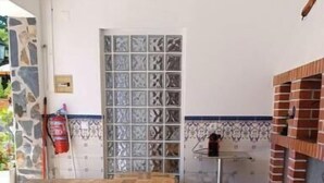 A wooden dining table in a room with patterned tile flooring and a brick oven. - Casa Machuca with swimming pool (Tomar)