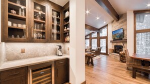 A modern kitchen with wooden cabinets, a marble countertop, and a built-in oven.