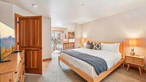 A bedroom with a wooden bed, a nightstand, a TV, and a wardrobe. - Park City in Prime Location/Sleeps 7/Summer AC (Park City)