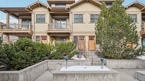 A multi-story residential building with balconies, a concrete courtyard, and a large evergreen tree. - Park City in Prime Location/Sleeps 7/Summer AC (Park City)