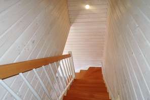 A wooden staircase with white railings and a wooden handrail. - Cottage in Niechorze Near Baltic Beach (Rewal)