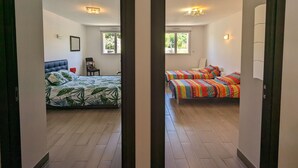 A hotel room with two beds, a window, and a chair.