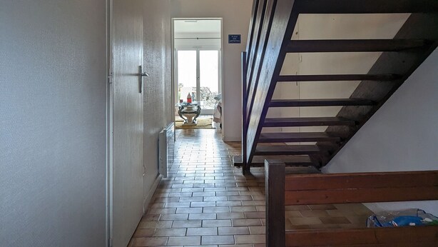 A hallway with a wooden staircase, a tiled floor, and a door leading to a bright room. - Gîte Renardeau: Comfort and Nature in Chassey-Beaupré (Chassey-Beaupré)