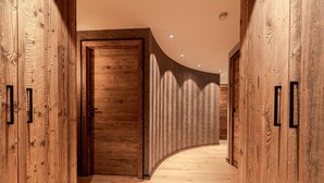 A wooden hallway with a curved ceiling and a door at the end.