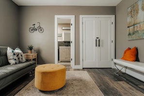 Un salon moderne avec un canapé, un pouf et un banc.