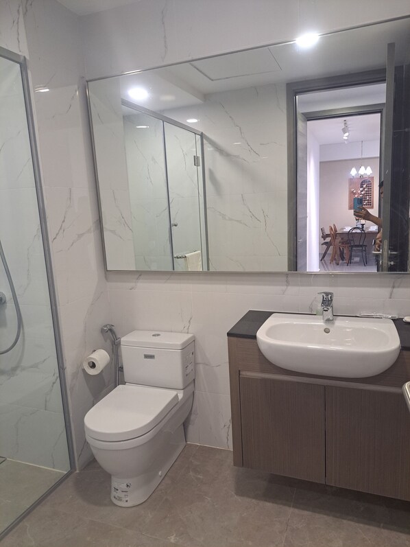 A bathroom with a toilet, sink, and shower.