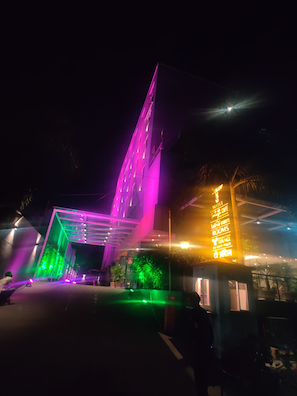 Fachada de hotel con señalización iluminada y diseño arquitectónico moderno.