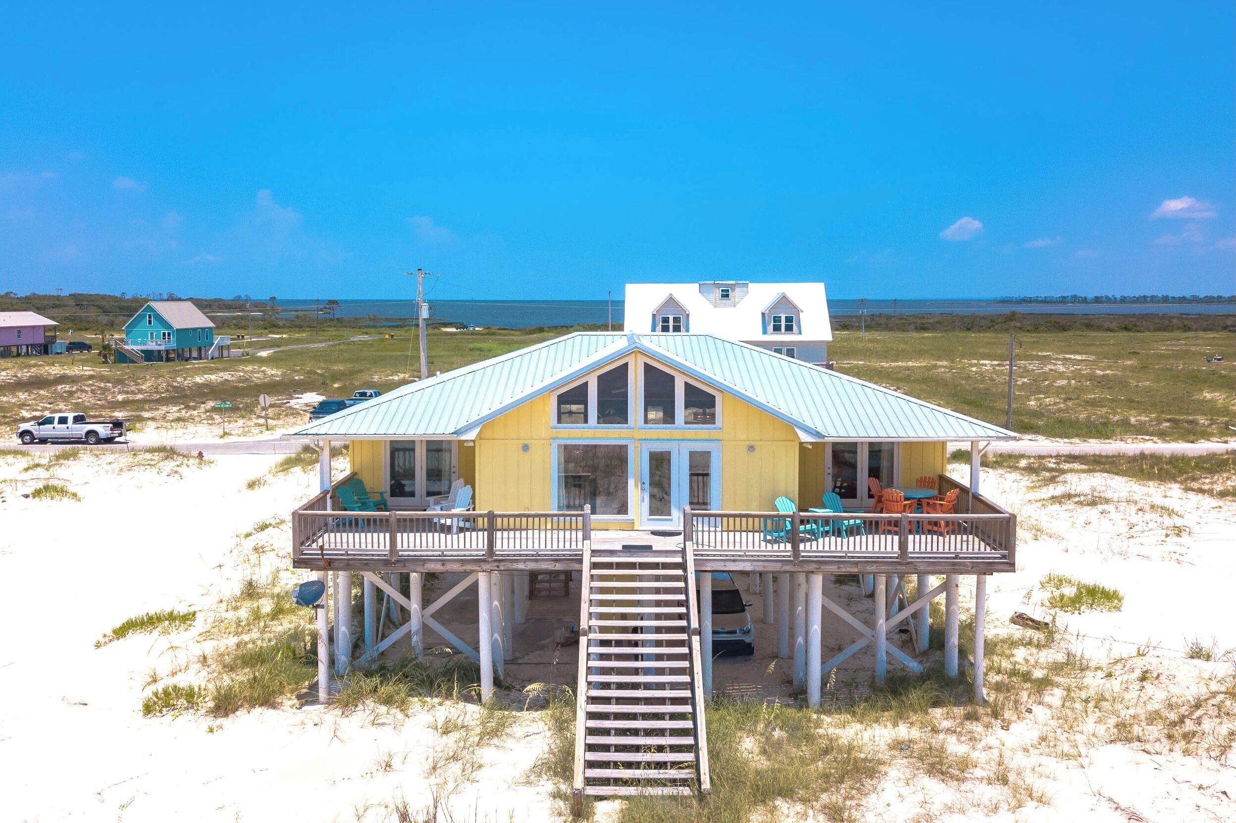 A beachfront house with a balcony and a covered porch.