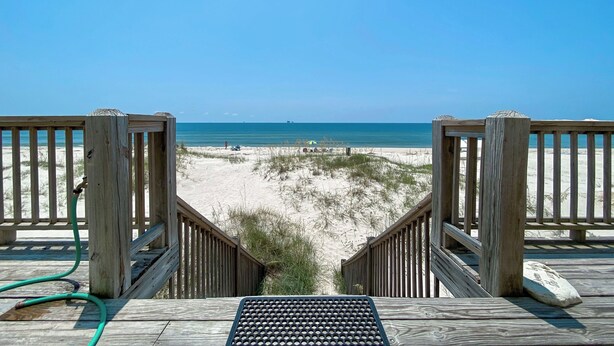 A wooden deck leading to a beach with a clear view of the ocean and sandy dunes. - Beautiful Gulf Front Home With Amazing Views! (Gulf Shores)