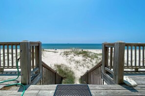 A wooden deck leading to a beach with a clear view of the ocean and sandy dunes. - Beautiful Gulf Front Home With Amazing Views! (Gulf Shores)
