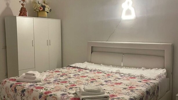 A bedroom with a bed, a wardrobe, and an air conditioning unit on the wall. - Guazzo Home b&b Rione Sanità  (Napoli)