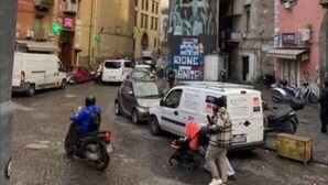 A street scene with a large mural on a building, a bridge in the background, and parked vehicles. - Guazzo Home b&b Rione Sanità  (Napoli)
