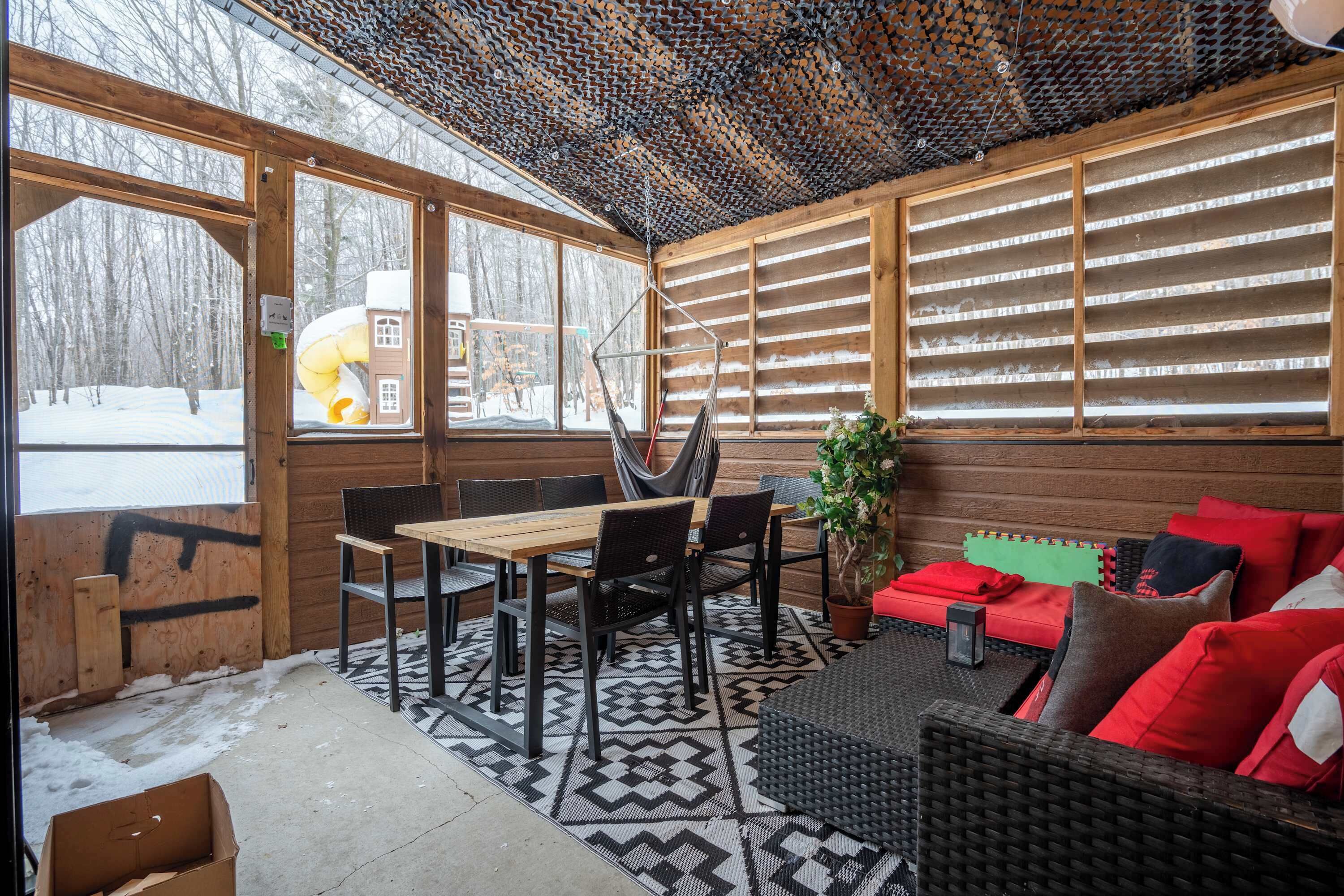 Un intérieur en bois comprenant un coin repas, un canapé et une grande fenêtre.