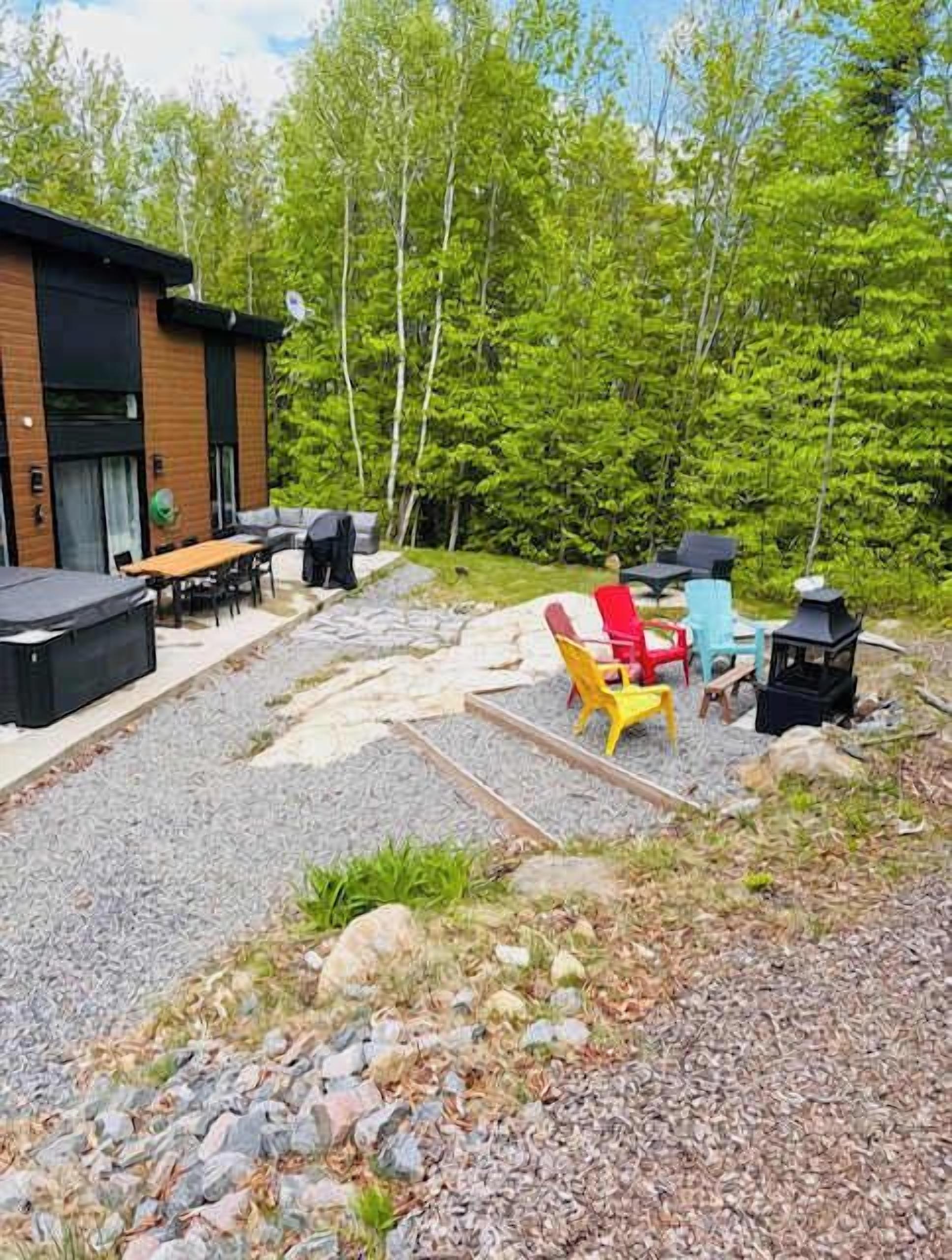 Un espace extérieur aménagé en terrasse, avec une plateforme en bois, des sièges et un barbecue.
